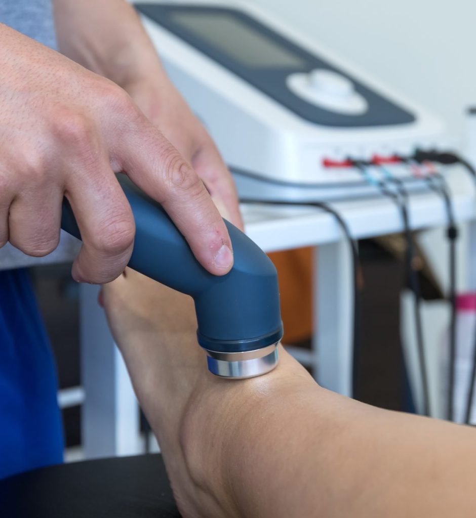 physical therapist applying electro stimulation to patients ankle