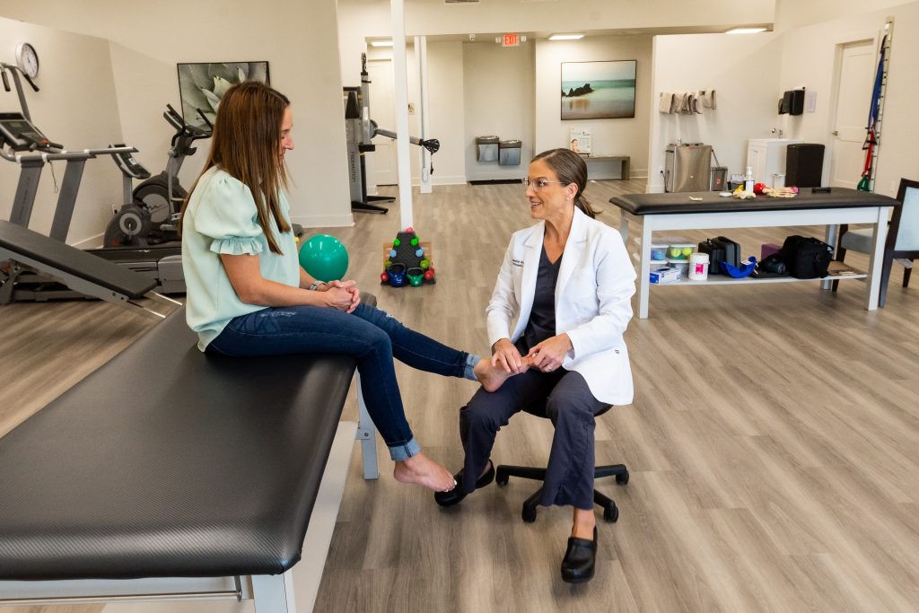 dr warner helping patient in physical therapy room