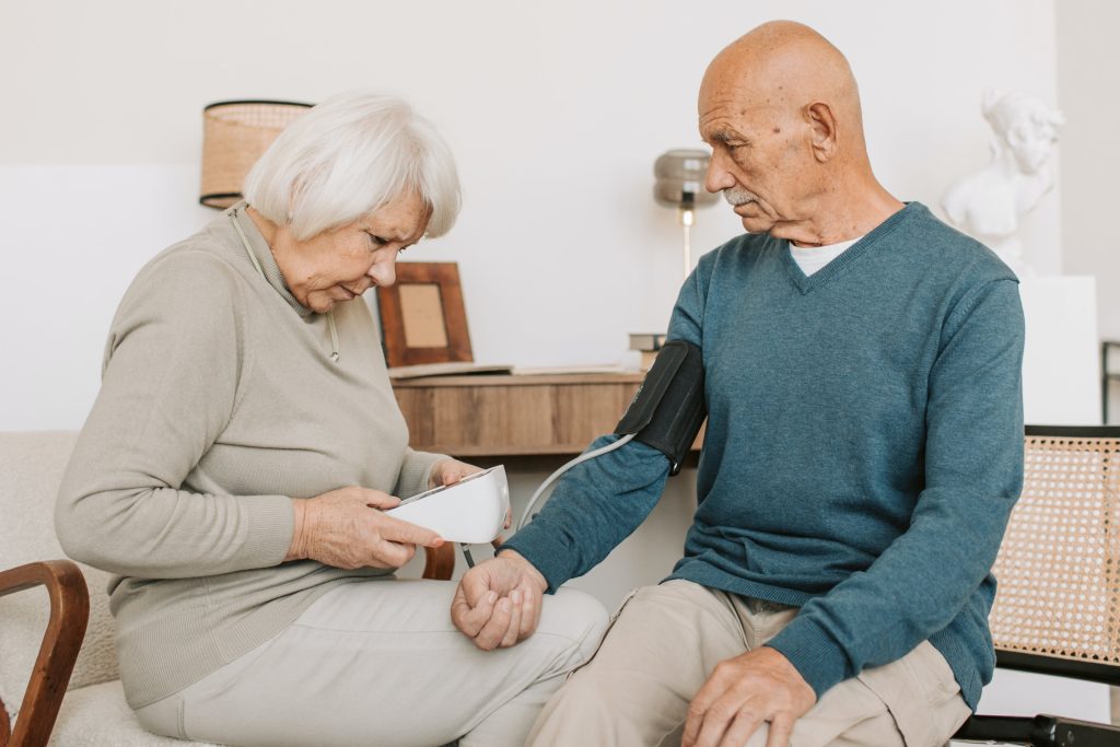 elder couple taking each others blood pressure at home